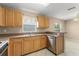 Well-lit kitchen features tile floors, a stainless steel dishwasher, and wood cabinetry at 476 Basking Ridge Ct, Ocoee, FL 34761