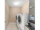 Well-equipped laundry room with tile floor, white washer and dryer, and essential utility connections at 476 Basking Ridge Ct, Ocoee, FL 34761