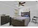 Comfortable bedroom featuring a ceiling fan, dark-wood furniture set and natural light from a window at 4905 Emilee Grace Ln, St Cloud, FL 34771