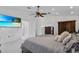 A spacious main bedroom with a ceiling fan, television, and ensuite bathroom for convenience at 4905 Emilee Grace Ln, St Cloud, FL 34771