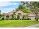 Charming home featuring a well-manicured lawn, mature trees, and attractive landscaping at 4905 Emilee Grace Ln, St Cloud, FL 34771
