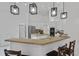 Kitchen with island, breakfast bar, white cabinets, stainless steel appliances, and pendant lighting at 4905 Emilee Grace Ln, St Cloud, FL 34771
