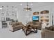 Open-concept living room with tile floors, neutral couches, brick accent, and modern light fixtures at 4905 Emilee Grace Ln, St Cloud, FL 34771