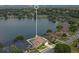 Aerial view of a lakeside home showcasing an outdoor pool and a well-manicured lawn, surrounded by mature trees at 529 Quail Down Dr, Debary, FL 32713