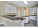 Modern kitchen features white cabinetry, dark countertops, and ceramic tile flooring at 529 Quail Down Dr, Debary, FL 32713