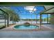 Relaxing pool with a waterfall feature and a screened-in enclosure overlooking a serene lake at 529 Quail Down Dr, Debary, FL 32713