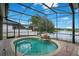 Heated pool with waterfall inside a screened enclosure overlooks a serene lake at 529 Quail Down Dr, Debary, FL 32713