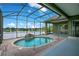 Inviting in-ground pool with a waterfall feature inside a screened enclosure, overlooking a lake at 529 Quail Down Dr, Debary, FL 32713