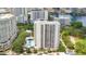 An aerial view displays a tall white condo building with balconies, surrounded by a pool, trees, and other city buildings at 530 E Central Blvd # 406, Orlando, FL 32801