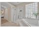 Bright bathroom featuring a bathtub, glass shower, and a privacy window at 533 Pickfair Ter, Lake Mary, FL 32746