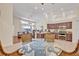 Open-concept kitchen with stainless appliances, wicker dining set, and views of the living room at 533 Pickfair Ter, Lake Mary, FL 32746