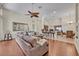 Open-concept living room featuring hardwood floors, a large sectional sofa, and a modern kitchen at 533 Pickfair Ter, Lake Mary, FL 32746
