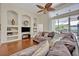 Spacious living room with a large couch, wood floors, and built-in shelving for displaying decor at 533 Pickfair Ter, Lake Mary, FL 32746