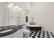 Bathroom featuring black and white checkerboard floors, a black soaking tub, and a vanity with black countertop at 548 S Hyer Ave # 1, Orlando, FL 32801