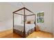 Bright bedroom featuring a four-poster bed, hardwood floors, and natural light streaming through the windows at 548 S Hyer Ave # 1, Orlando, FL 32801