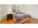 Bedroom featuring a floral quilt, hardwood floors, and natural light from the window at 548 S Hyer Ave # 1, Orlando, FL 32801