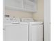 Well-equipped laundry room with full size white washer and dryer and shelving above at 548 S Hyer Ave # 1, Orlando, FL 32801