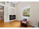 Cozy living room with a fireplace, an accent chair, and view to lush landscaping at 548 S Hyer Ave # 1, Orlando, FL 32801