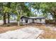 Large, shady backyard featuring mature trees and a concrete patio area at 558 Tyler Ave, Deltona, FL 32725
