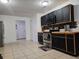 Beautiful kitchen equipped with stainless steel appliances, black cabinets, and a modern tile backsplash at 558 Tyler Ave, Deltona, FL 32725
