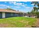 Backyard features a large green lawn, dark blue siding, and a screened lanai with a fenced pool at 704 Tangerine Ct, Winter Garden, FL 34787