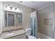 Well-lit bathroom features a granite countertop, white cabinets, and shower with tiled walls and a recessed shelf at 704 Tangerine Ct, Winter Garden, FL 34787