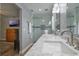 This bathroom features a walk-in shower, dual sinks, marble countertops, and stylish lighting at 704 Tangerine Ct, Winter Garden, FL 34787