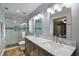 Modern bathroom showcases dual sinks, marble countertops, walk-in shower, and stylish fixtures at 704 Tangerine Ct, Winter Garden, FL 34787