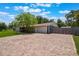 Paver driveway leads to a two-car garage, complemented by partial fencing and verdant lawn and mature trees at 704 Tangerine Ct, Winter Garden, FL 34787