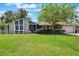 Charming single-story home featuring stone accents, blue siding, mature trees and a lush green lawn at 704 Tangerine Ct, Winter Garden, FL 34787