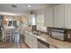 Bright kitchen boasts granite counters, stainless appliances, and a dining area with natural light at 704 Tangerine Ct, Winter Garden, FL 34787