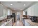 Well-lit kitchen featuring granite countertops, stainless appliances and white cabinets at 704 Tangerine Ct, Winter Garden, FL 34787