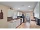 Modern kitchen with stainless steel appliances, granite counters, and white cabinetry at 704 Tangerine Ct, Winter Garden, FL 34787