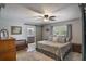 Spacious main bedroom featuring a ceiling fan, ensuite bath, and sliding barn door entrance at 704 Tangerine Ct, Winter Garden, FL 34787