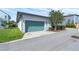 Attached garage features a teal garage door, side lighting, and a concrete driveway at 8518 Nemours Pkwy, Orlando, FL 32827