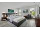Comfortable main bedroom featuring a king bed, accent chair, and two windows offering natural light at 8518 Nemours Pkwy, Orlando, FL 32827