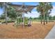 Community playground features a shade cover with climbing and play structures at 8518 Nemours Pkwy, Orlando, FL 32827