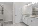 Bathroom features a double sink vanity and shower with a glass door at 8822 Interlocking Ct, Davenport, FL 33896