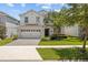 Two-story home featuring a manicured lawn, beautiful landscaping, and an attached two-car garage at 8822 Interlocking Ct, Davenport, FL 33896