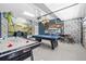 Spacious game room with air hockey, pool table, murals, and bar seating at 8822 Interlocking Ct, Davenport, FL 33896
