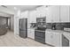 Modern kitchen with stainless steel appliances, white cabinetry, and a complementary tile backsplash at 8822 Interlocking Ct, Davenport, FL 33896