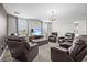 Spacious living room featuring multiple leather recliners, a large TV, and plenty of natural light at 8822 Interlocking Ct, Davenport, FL 33896