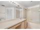 Well-lit bathroom with a large vanity, framed mirror, combined shower and tub, and linen closet at 9145 Fort Jefferson Blvd, Orlando, FL 32822