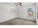 Cozy bedroom with carpet, a ceiling fan, and a window overlooking the neighborhood at 9145 Fort Jefferson Blvd, Orlando, FL 32822