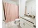 Neutral bathroom with a shower featuring a pink curtain and a light gray countertop at 949 Leader St, Davenport, FL 33896