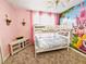 Whimsical bedroom with bunk beds, pink walls, princess mural and cozy carpet at 949 Leader St, Davenport, FL 33896