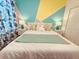 Bedroom with a queen bed, vibrant accent wall, and matching nightstands at 949 Leader St, Davenport, FL 33896