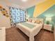 Bright bedroom with colorful accent wall, floral curtains, and stylish decor at 949 Leader St, Davenport, FL 33896