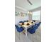 Dining room with a white table, eight blue chairs, and modern lighting at 949 Leader St, Davenport, FL 33896