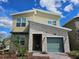 Charming home features a stone facade, green garage door, and meticulously manicured landscaping at 949 Leader St, Davenport, FL 33896